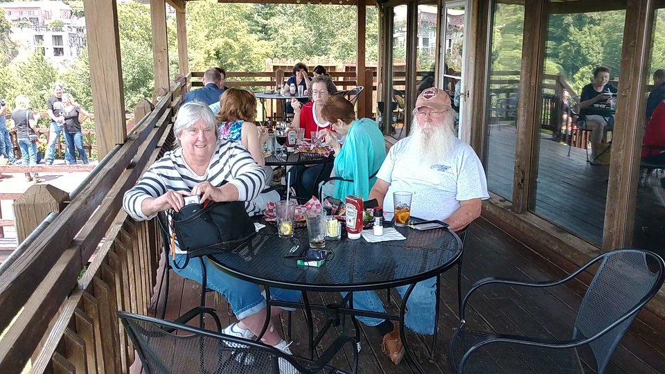 Restaurant deck seating beside wide mountain views.